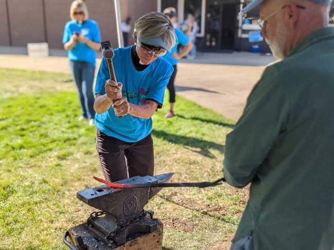 RAWtools-colorado-springs-disarming-network a man and woman hammering metal on an anvil