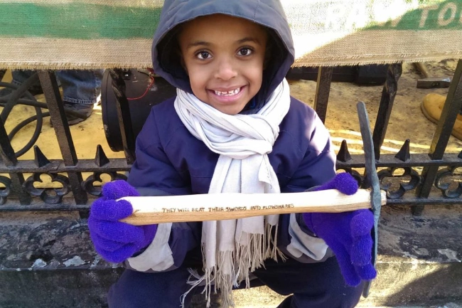 Young girl holding an engraved tool handle made from gun parts